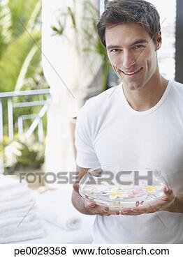 Stock Photo - man with a bowl 
full of floating 
flowers. fotosearch 
- search stock 
photos, pictures, 
images, and photo 
clipart