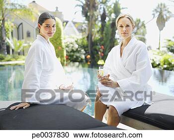 Stock Photography - two women relaxing 
in bathrobes by 
a pool. fotosearch 
- search stock 
photos, pictures, 
images, and photo 
clipart