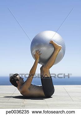 Stock Image - man working out 
with an exercise 
ball. fotosearch 
- search stock 
photos, pictures, 
images, and photo 
clipart