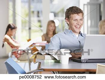 Banco de Imagem - jovem,  homem, 
 escola,  laptop, 
 livros. fotosearch 
- busca de fotos, 
imagens e clipart