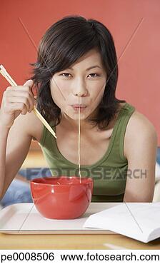 Banco de Imagem - jovem,  mulher, 
 comer,  tigela, 
 noodles,  chopsticks, 
 cafeteria. fotosearch 
- busca de fotos, 
imagens e clipart