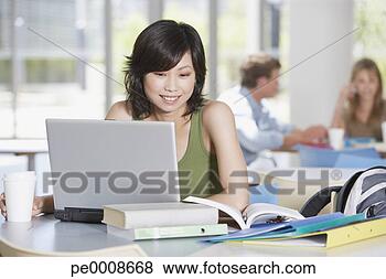 Banco de Imagem - jovem,  mulher, 
 laptop,  livros, 
 escola. fotosearch 
- busca de fotos, 
imagens e clipart