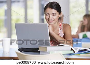 Arquivo de Fotografias - jovem,  mulher, 
 laptop,  livros, 
 escola. fotosearch 
- busca de fotos, 
imagens e clipart