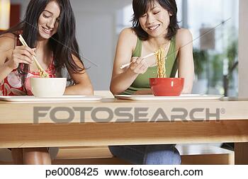 Banco de Imagem - jovem,  mulheres, 
 comer,  tigela, 
 noodles,  chopsticks, 
 cafeteria. fotosearch 
- busca de fotos, 
imagens e clipart