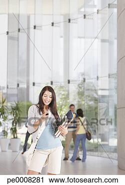 Stock Photography - young woman with 
cell phone and 
books at school. 
fotosearch - search 
stock photos, 
pictures, images, 
and photo clipart