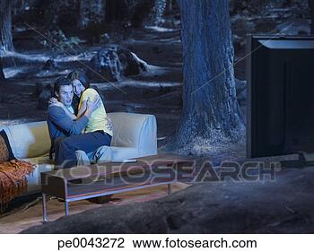 Stock Photo - a frightened couple 
watching television 
outdoors in the 
woods. fotosearch 
- search stock 
photos, pictures, 
images, and photo 
clipart