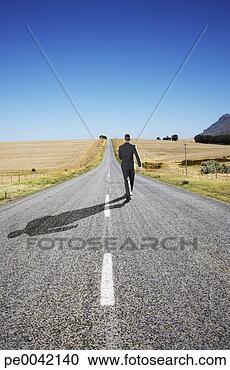 Arquivo de Fotografias - homem negócios, 
 meio,  estrada, 
 andar,  afastado. 
fotosearch - busca 
de fotos, imagens 
e clipart