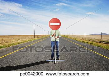 Arquivo de Fotografias - homem,  segurando, 
 sinal,  meio, 
 estrada. fotosearch 
- busca de fotos, 
imagens e clipart