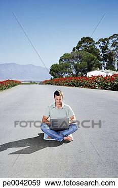 Stock Photograph - a man on a laptop 
in the middle 
of the road. fotosearch 
- search stock 
photos, pictures, 
images, and photo 
clipart