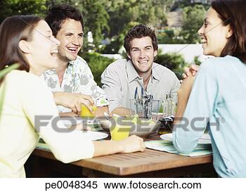 Stock Image - friends enjoying 
an outdoor meal. 
fotosearch - search 
stock photos, 
pictures, images, 
and photo clipart