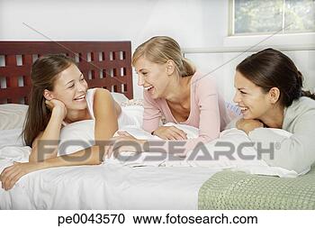 Arquivo de Fotografias - três,  namoradas, 
 falando,  cama. 
fotosearch - busca 
de fotos, imagens 
e clipart