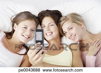 Banco de Imagem - três,  namoradas, 
 usando,  quadro, 
 telefone. fotosearch 
- busca de fotos, 
imagens e clipart
