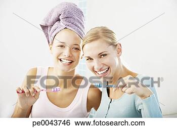 Stock Photo - two girlfriends 
in a bathroom 
brushing their 
teeth. fotosearch 
- search stock 
photos, pictures, 
images, and photo 
clipart