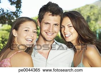 Stock Image - a young man with 
two young woman 
embracing him. 
fotosearch - search 
stock photos, 
pictures, images, 
and photo clipart