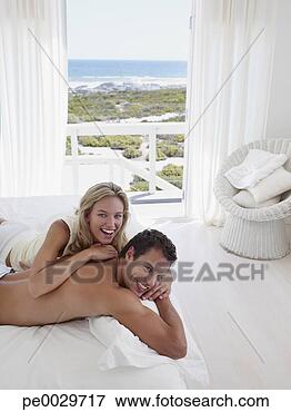 Foto - par,  abraçar, 
 cama. fotosearch 
- busca de fotos, 
imagens e clipart