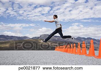 Picture - man jumping over 
safety cones. 
fotosearch - search 
stock photos, 
pictures, images, 
and photo clipart
