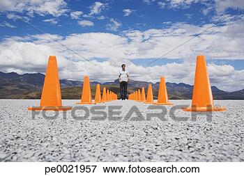 Picture - man standing in-between 
two rows of safety 
cones. fotosearch 
- search stock 
photos, pictures, 
images, and photo 
clipart