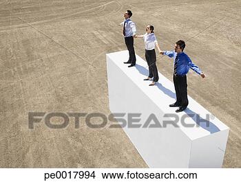 Stock Photo - three businesspeople 
standing on wall 
outdoors holding 
hands. fotosearch 
- search stock 
photos, pictures, 
images, and photo 
clipart