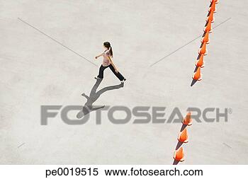 Stock Image - woman walking 
through opening 
in row of traffic 
cones. fotosearch 
- search stock 
photos, pictures, 
images, and photo 
clipart
