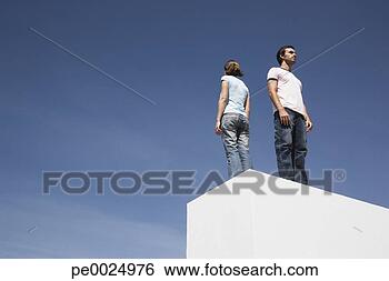 Stock Photo - man and woman 
standing on box 
back to back outdoors 
with blue sky. 
fotosearch - search 
stock photos, 
pictures, images, 
and photo clipart