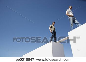 Picture - two men walking 
on board between 
two walls outdoors. 
fotosearch - search 
stock photos, 
pictures, images, 
and photo clipart
