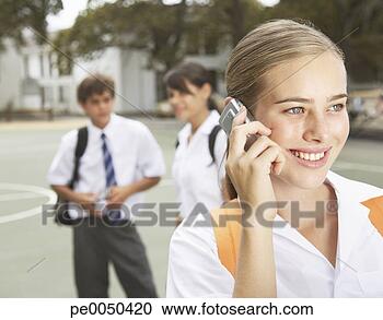 Stock Photography - students outside 
their school one 
on a cellular 
phone. fotosearch 
- search stock 
photos, pictures, 
images, and photo 
clipart