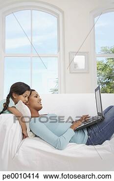 Stock Photo - mother on sofa 
with laptop and 
girl watching. 
fotosearch - search 
stock photos, 
pictures, images, 
and photo clipart