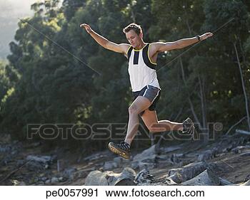 Stock Photography - a man outdoors 
jumping over logs. 
fotosearch - search 
stock photos, 
pictures, images, 
and photo clipart