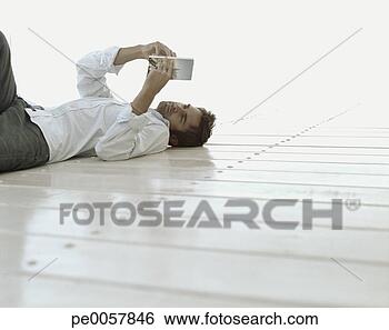 Banco de Imagem - homem,  mentindo, 
 baixo,  leitura. 
fotosearch - busca 
de fotos, imagens 
e clipart