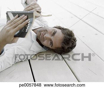 Stock Photo - a man lying down 
and reading. fotosearch 
- search stock 
photos, pictures, 
images, and photo 
clipart