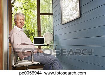 Stock Photo - man sitting at 
his desk in home 
office. fotosearch 
- search stock 
photos, pictures, 
images, and photo 
clipart