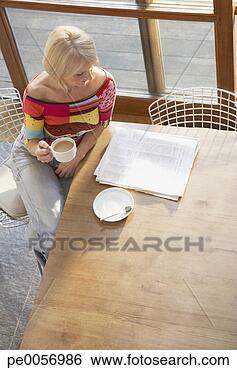 Stock Photo - woman with coffee 
and a newspaper 
at kitchen table. 
fotosearch - search 
stock photos, 
pictures, images, 
and photo clipart