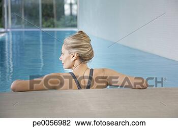 Stock Photo - woman leaning 
against an indoor 
pool ledge relaxed. 
fotosearch - search 
stock photos, 
pictures, images, 
and photo clipart