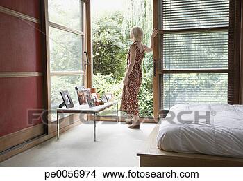 Stock Photo - woman looking 
outdoors from 
bedroom patio 
door. fotosearch 
- search stock 
photos, pictures, 
images, and photo 
clipart