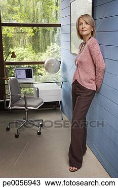 Stock Photo - woman standing 
against a wall 
in home office. 
fotosearch - search 
stock photos, 
pictures, images, 
and photo clipart