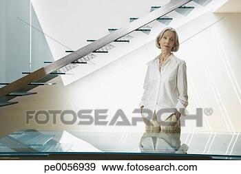 Stock Photograph - woman standing 
near staircase. 
fotosearch - search 
stock photos, 
pictures, images, 
and photo clipart