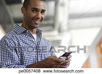 Stock Photo - businessman holding 
his mobile phone 
in hall. fotosearch 
- search stock 
photos, pictures, 
images, and photo 
clipart