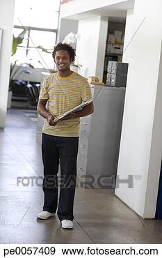 Stock Photograph - businessman standing 
with laptop in 
office. fotosearch 
- search stock 
photos, pictures, 
images, and photo 
clipart