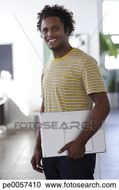 Stock Photography - businessman standing 
with laptop in 
office. fotosearch 
- search stock 
photos, pictures, 
images, and photo 
clipart