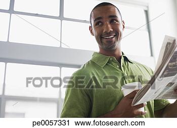 Stock Photography - businessman standing 
in office holding 
coffee cup and 
newspaper. fotosearch 
- search stock 
photos, pictures, 
images, and photo 
clipart