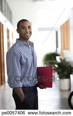 Stock Photo - businessman standing 
in office hall 
smiling. fotosearch 
- search stock 
photos, pictures, 
images, and photo 
clipart