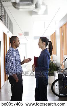 Stock Image - two businesspeople 
standing in an 
office hall. fotosearch 
- search stock 
photos, pictures, 
images, and photo 
clipart
