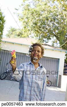 Stock Photo - boy standing in 
driveway with 
toy bubble gun. 
fotosearch - search 
stock photos, 
pictures, images, 
and photo clipart