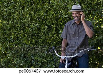 Foto - celular,  telefone, 
 sentando,  bicicleta. 
fotosearch - busca 
de fotos, imagens 
e clipart