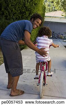 Stock Photo - father teaching 
daughter to ride 
bicycle in driveway. 
fotosearch - search 
stock photos, 
pictures, images, 
and photo clipart