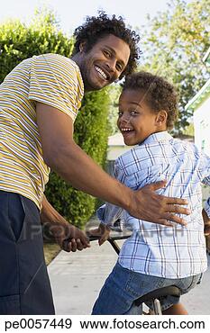 Stock Photograph - father teaching 
son to ride bicycle 
in driveway. fotosearch 
- search stock 
photos, pictures, 
images, and photo 
clipart