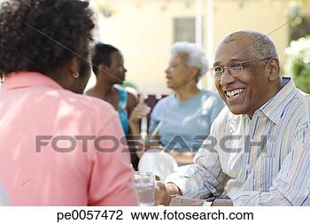Stock Photo - two generations 
of couples sitting 
outdoors talking. 
fotosearch - search 
stock photos, 
pictures, images, 
and photo clipart