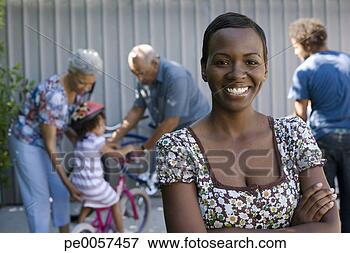 Picture - woman standing 
in driveway with 
people in background. 
fotosearch - search 
stock photos, 
pictures, images, 
and photo clipart
