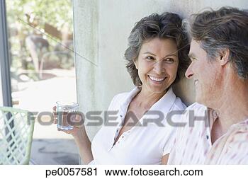 Stock Photography - couple outdoors 
on patio laughing. 
fotosearch - search 
stock photos, 
pictures, images, 
and photo clipart