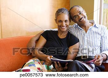 Stock Photo - couple on sofa 
in modern home 
with magazine. 
fotosearch - search 
stock photos, 
pictures, images, 
and photo clipart